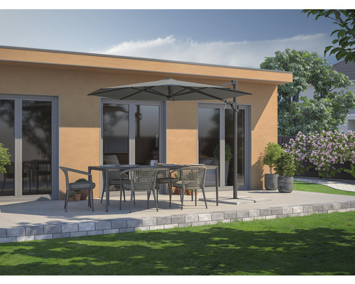 Terrassenszene mit Esstisch, Stühlen und Sonnenschirm vor einem Gebäude