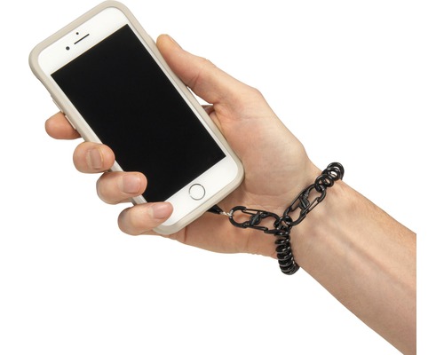 Ein Smartphone mit Handyband wird von einer Hand gehalten.