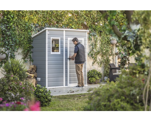 Garten Szene mit Geräteschuppen und einer Person, die die Tür öffnet