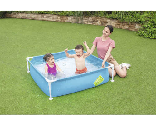 Szene mit Kindern und einer Erwachsenen in einem Planschbecken im Garten.