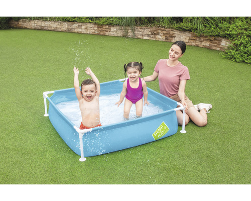 Familie mit Kindern im blauen Planschbecken im Garten