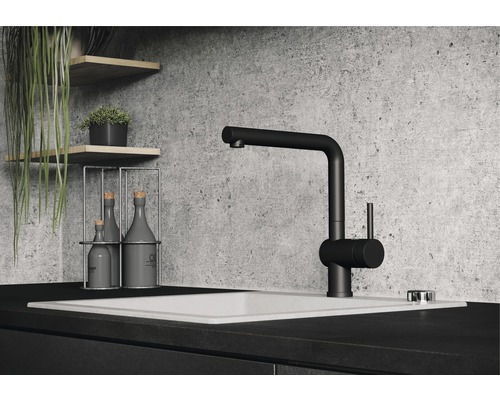 Schwarze Küchenarmatur an einem Waschbecken mit Dekorationsartikeln auf Regalen