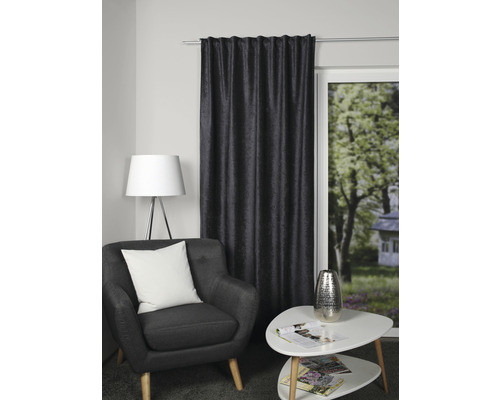 Wohnzimmer mit Sessel, Beistelltisch und Vorhang