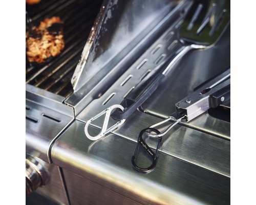 Grillzubehör mit Werkzeugen und Verbindungsgliedern auf einem Grill.