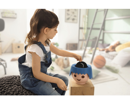 Mädchen spielt mit einer Spardose im Kinderzimmer