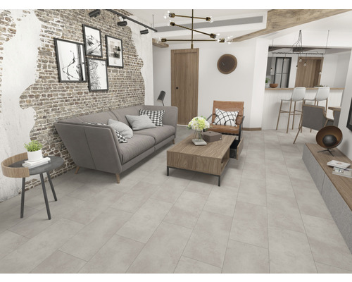 Wohnzimmer mit Sofa, Couchtisch und Fliesenboden