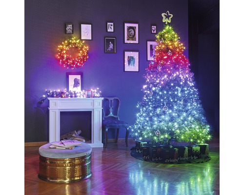 Dekoratives Wohnzimmer mit beleuchtetem Weihnachtsbaum, Weihnachtskranz und Kamin