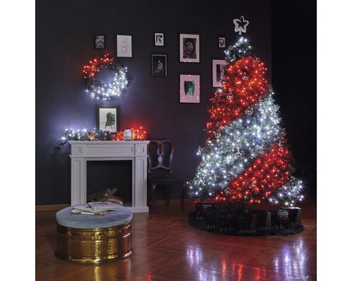 Weihnachtlich dekoriertes Wohnzimmer mit Weihnachtsbaum, Lichterketten, Kamin und Bildern an der Wand.