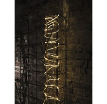 Dekorative Lichterkette auf einem Metallgitter an einer Backsteinmauer