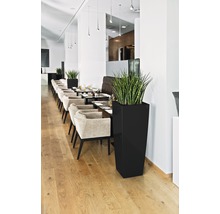 Restaurant mit Tischen, Stühlen und hohen Pflanzgefäßen