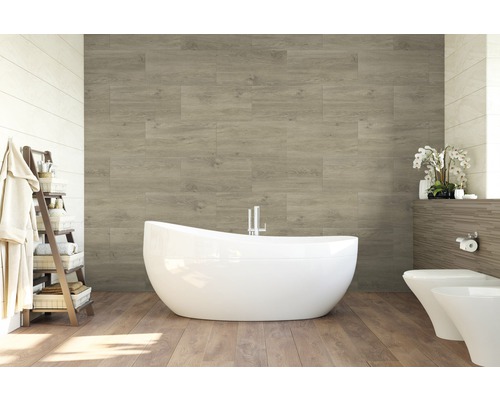 Helles Badezimmer mit Badewanne, Toilette, Bidet und Wandverkleidung in Holzoptik