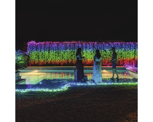 Gartenparty am Pool mit farbiger Lichterkette an der Hecke