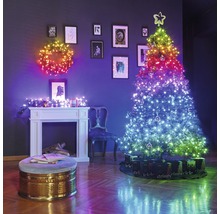 Festlicher Raum mit beleuchtetem Weihnachtsbaum, Türkranz und Kaminkonsole