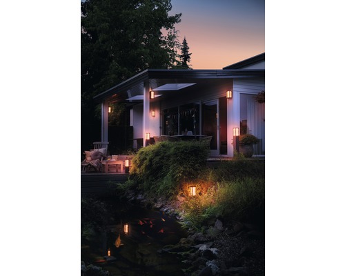 Beleuchtetes Haus mit Garten und Teich am Abend