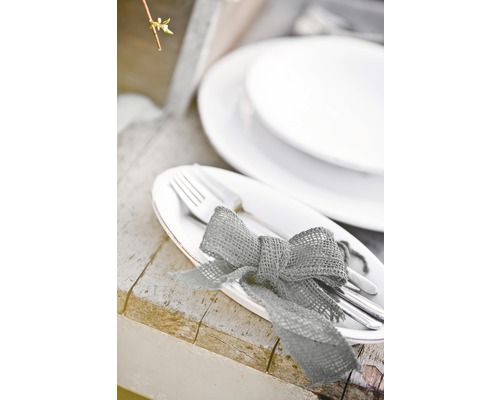 Gedeckter Tisch mit Tellern, Besteck und Schleife aus Sackleinen