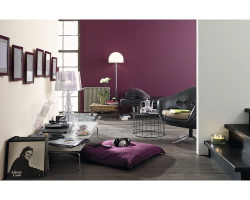 Wohnzimmer mit Plattenspieler, Schallplatten, Sitzkissen und Sessel vor einer Wand