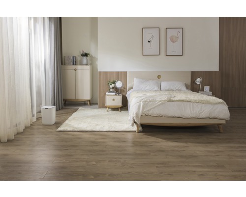 Schlafzimmer mit Bett, Nachttisch, Kommode, Teppich und Luftreiniger