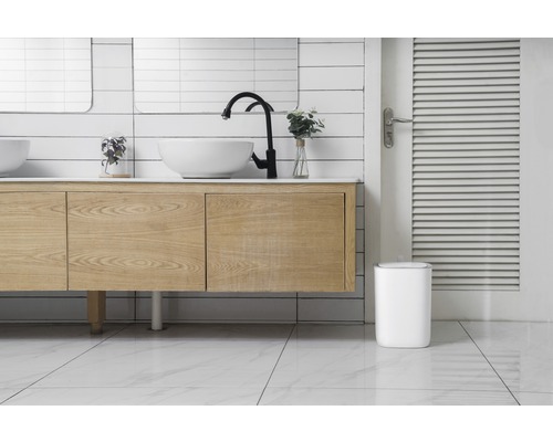 Modernes Badezimmer mit Waschtisch, Aufsatzwaschbecken, Armatur und Abfalleimer.