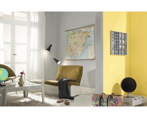 Wohnzimmer mit Sessel, Stehlampe und Wandkarte