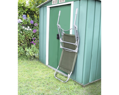 Grünes Gartenhaus mit einem zusammengeklappten Liegestuhl
