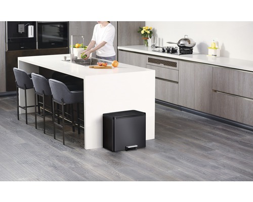 Moderne Küche mit Kücheninsel, Barhockern und einem schwarzen Tretabfalleimer.