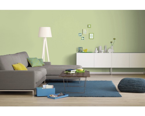 Helles Wohnzimmer mit grauer Couch, weißem Sideboard und grüner Wandfarbe