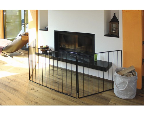 Wohnraum mit Kaminschutzgitter aus Metall vor einem Kamin