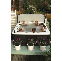 Eine Gruppe von Personen entspannt sich in einem Whirlpool im Freien.