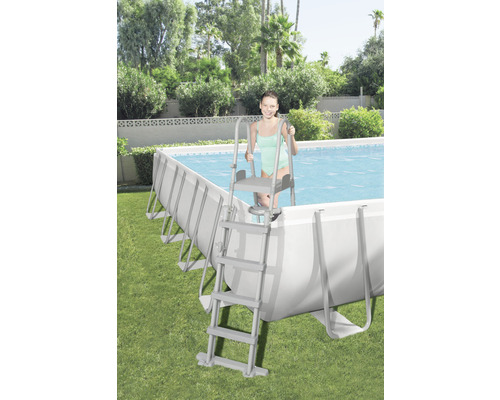 Schwimmbecken mit Leiter im Garten mit junger Frau