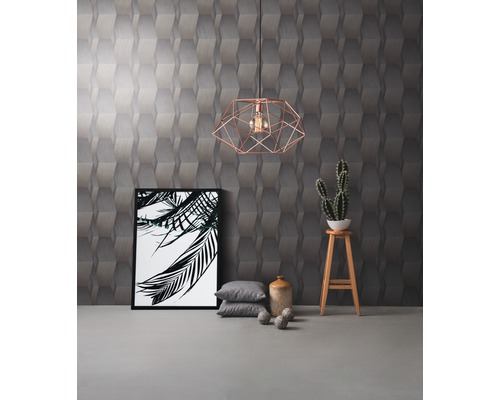 Einrichtungsidee mit geometrischer Tapete, Pendelleuchte, Bild, Kissen und Dekoration auf einem Hocker.