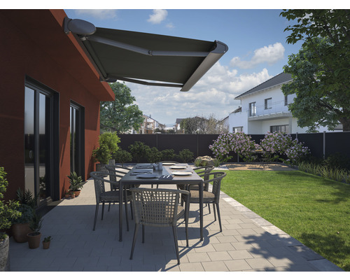 Terrasse mit Markise, Gartentisch und Stühlen vor einem Haus