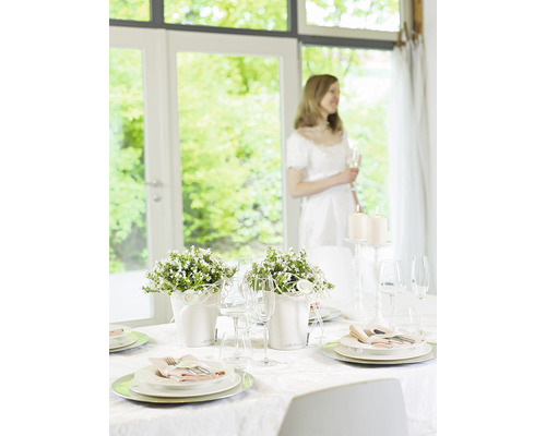 Festlich gedeckter Tisch mit Blumenarrangements und Kerzen für eine besondere Gelegenheit.