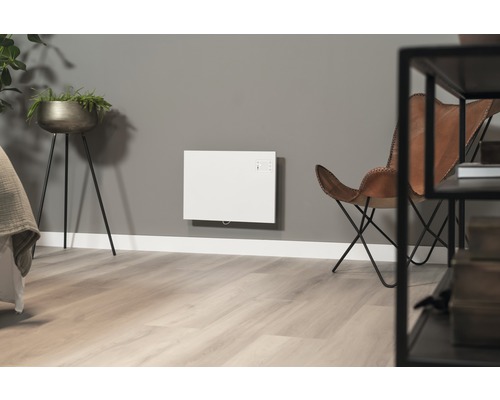 Wohnraum mit Wandheizung, Sessel und Pflanze