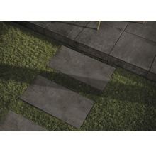Pflastersteine auf Rasen verlegt, bilden einen Gartenweg.