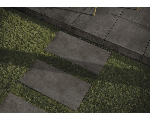 Pflastersteine auf Rasen verlegt, bilden einen Gartenweg.