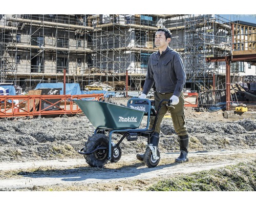 Ein Mann bedient eine Makita Schubkarre auf einer Baustelle.