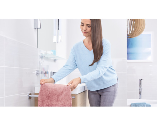 Helles Badezimmer mit Frau, Waschtisch und Handtuchhalter