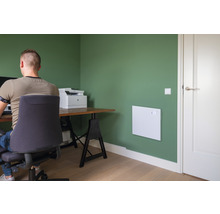 Büro mit Heizpaneel an der Wand, Schreibtisch und Bürostuhl.