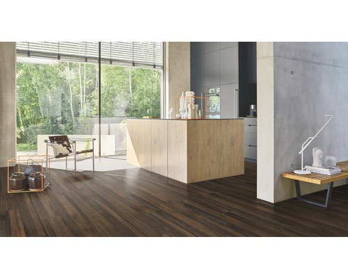 Heller, moderner Raum mit dunklem Holzboden, Kücheninsel und großem Fenster