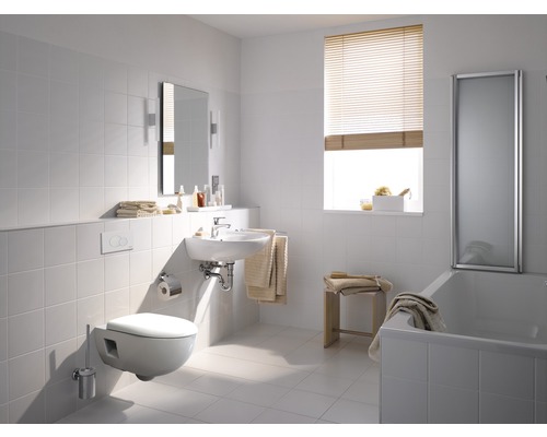 Helles Badezimmer mit Toilette, Waschbecken, Spiegel und Badewanne