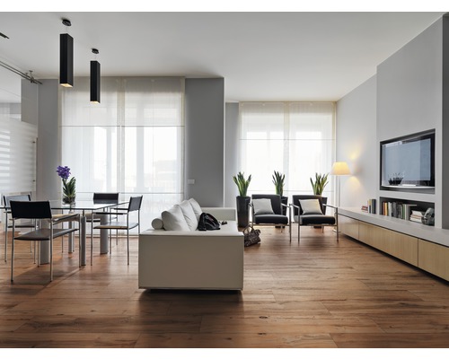 Heller Wohnraum mit Holzboden, Sofa, Sesseln, Tisch und TV-Element