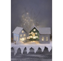 Dekorative Häuser mit Schnee bedeckt und beleuchteten Fenstern für eine festliche Atmosphäre.