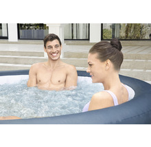 Zwei Personen entspannen in einem aufblasbaren Whirlpool im Freien.