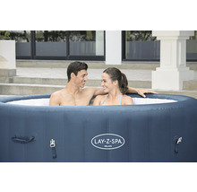 Aufblasbarer Lay-Z-Spa Milan Whirlpool mit zwei Personen im Garten.
