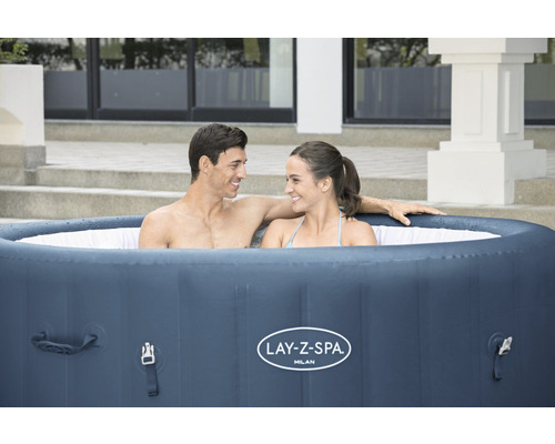 Aufblasbarer Lay-Z-Spa Milan Whirlpool mit zwei Personen im Garten.