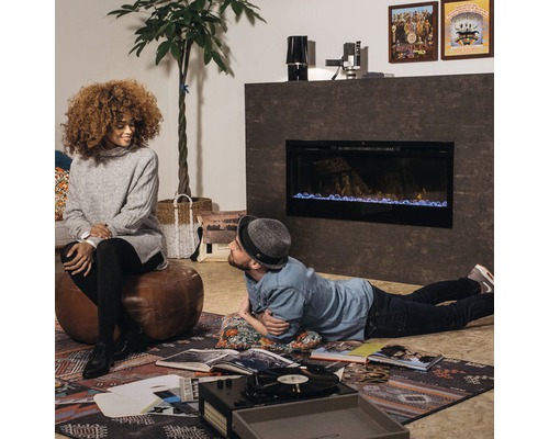 Wohnzimmer mit Elektrokamin, Schallplattenspieler und Personen