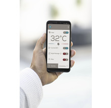 Ein Smartphone mit einer App zur Steuerung von Heizung, Massage und Filterfunktionen wird in der Hand gehalten.