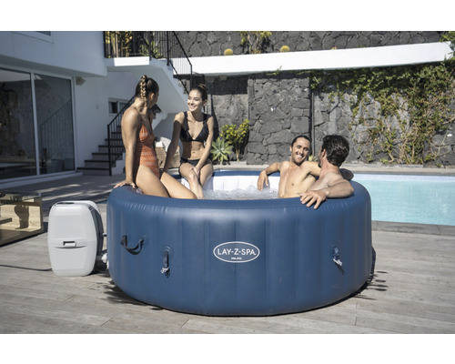 Aufblasbarer Lay-Z-Spa Milan Whirlpool mit vier Personen im Garten.