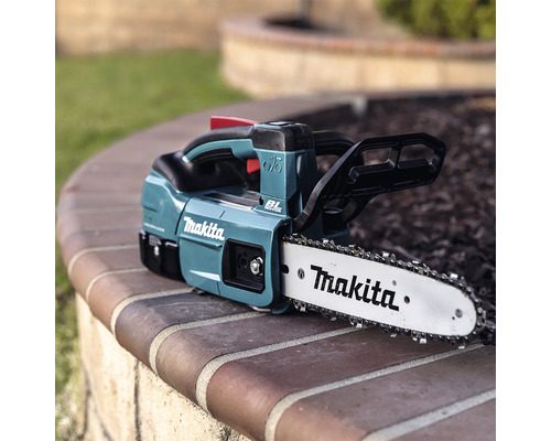 Makita Akku-Kettensäge auf einer Mauer
