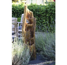 Gartenszene mit Baumstammbrunnen, Gartenmöbeln und Lavendel
